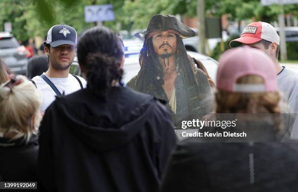 Fans hold a cardboard cutout of actor Johnny Depp in his role as Jack Sparrow from "Pirates of the Caribbean" outside the Fairfax County Courthouse...