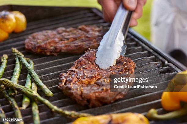 grillen von rib eye steaks auf dem grill - rib eye steak stock-fotos und bilder