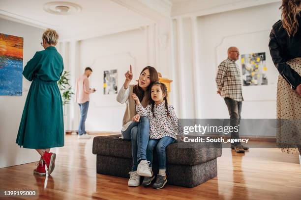 mother and daughter in art gallery - art museum stockfoto's en -beelden