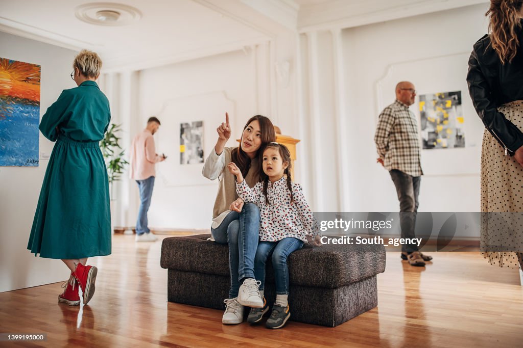 Mother and daughter in art gallery