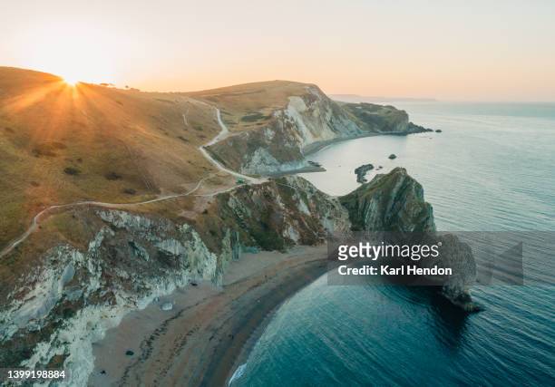 a sunrise view of durdle door beach in dorset, uk - dorset uk - fotografias e filmes do acervo