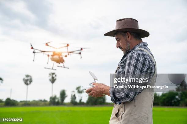 man flying a drone at sunset - drone pilot stock pictures, royalty-free photos & images