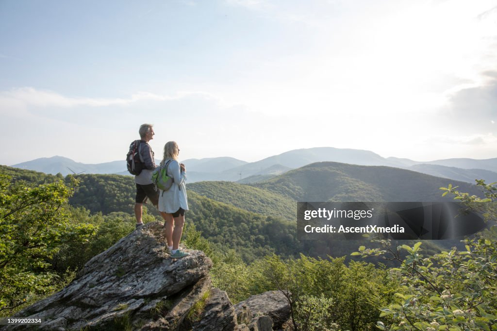 Mature hiking couple relax at viewpoint
