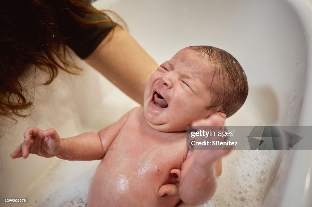 Close-Up Of Baby Crying While Taking Bath At Home