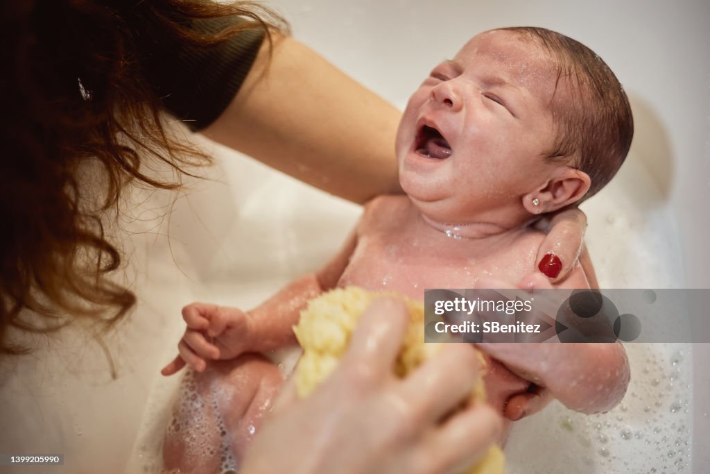 Newborn baby is being bathed