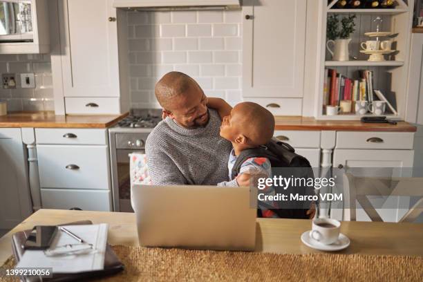 vater, der von zu hause aus arbeitet und sich um seinen sohn kümmert. der kleine junge geht morgens zur schule, während sein vater bei seinem remote-job einen laptop benutzt. vereinbarkeit von familie und beruf - großvater vater sohn business stock-fotos und bilder