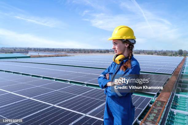 women engineer at energy solar panel roof. - elektrischer generator stock-fotos und bilder
