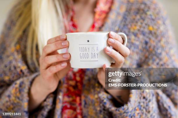 close up of woman hand holding a cup of tea or coffee - enjoying coffee cafe morning light stock-fotos und bilder