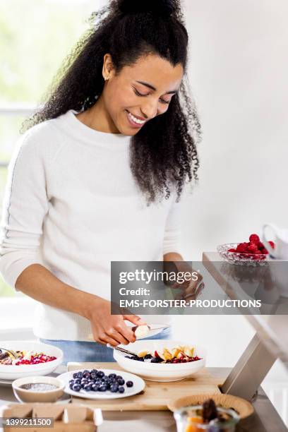 woman making healthy breakfast in modern kitchen - same person different outfits stock-fotos und bilder