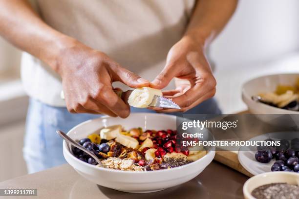 close up of woman making healthy breakfast in kitchen with fruits and yogurt - salud y belleza fotografías e imágenes de stock