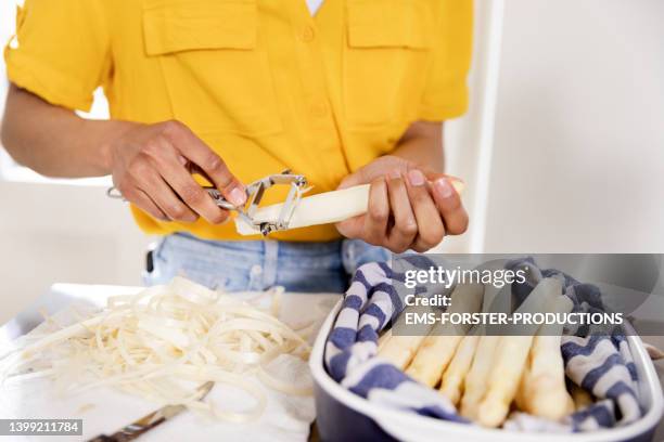 close up of female hands,  peeling white asparagus at home in the modern kitchen - peeled stock pictures, royalty-free photos & images