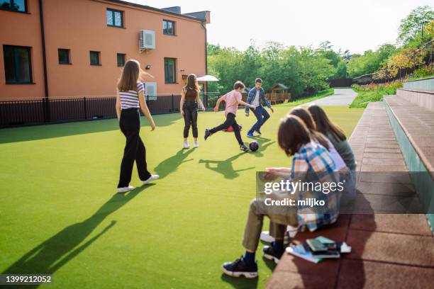 estudantes do ensino médio estão descansando e se divertindo com bola no pátio da escola - high school football - fotografias e filmes do acervo