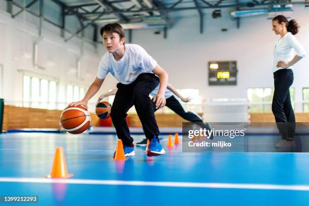 physical education class and sport training in high school - kids playing basketball indoor stock pictures, royalty-free photos & images