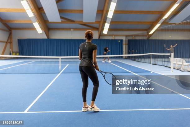 women playing tennis on indoor hardcourt - tennis outfit stock pictures, royalty-free photos & images