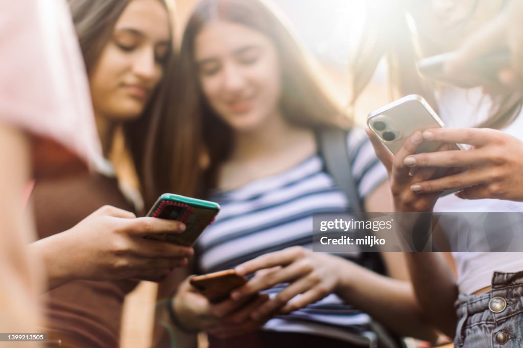 Mädchen im Teenageralter haben Spaß und Gespräche mit ihren Mobiltelefonen