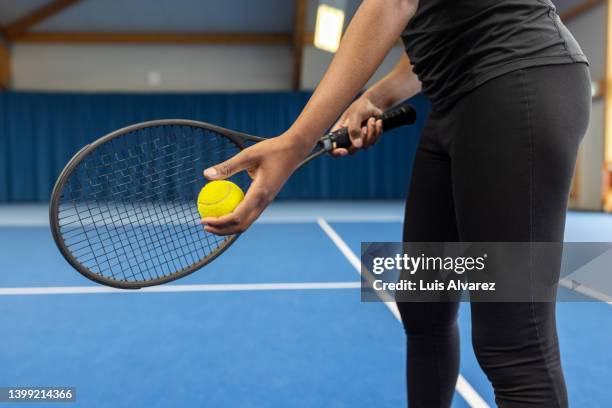 close-up of a woman serving a tennis ball in a match - schlägersport stock-fotos und bilder