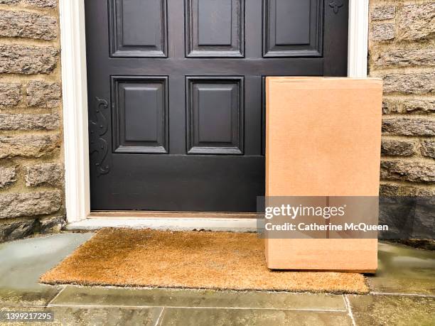 large brown box package left at front residential door - threshold stock-fotos und bilder