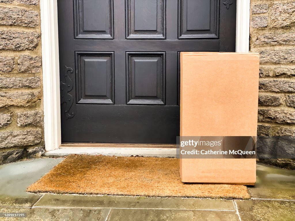 Large brown box package left at front residential door