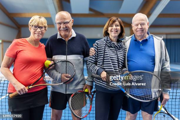 portrait of mature couples in sportswear standing on a tennis court - 80s tennis players stock pictures, royalty-free photos & images