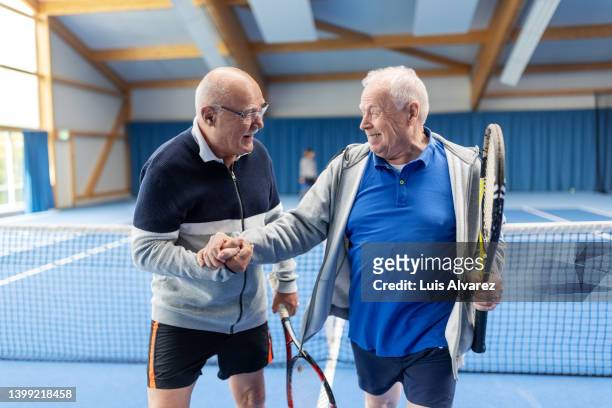 senior tennis players celebrating a win of game - 80s tennis players stock pictures, royalty-free photos & images