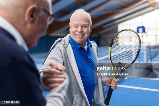 two senior tennis players shaking hands on tennis court - 80s tennis players stock pictures, royalty-free photos & images