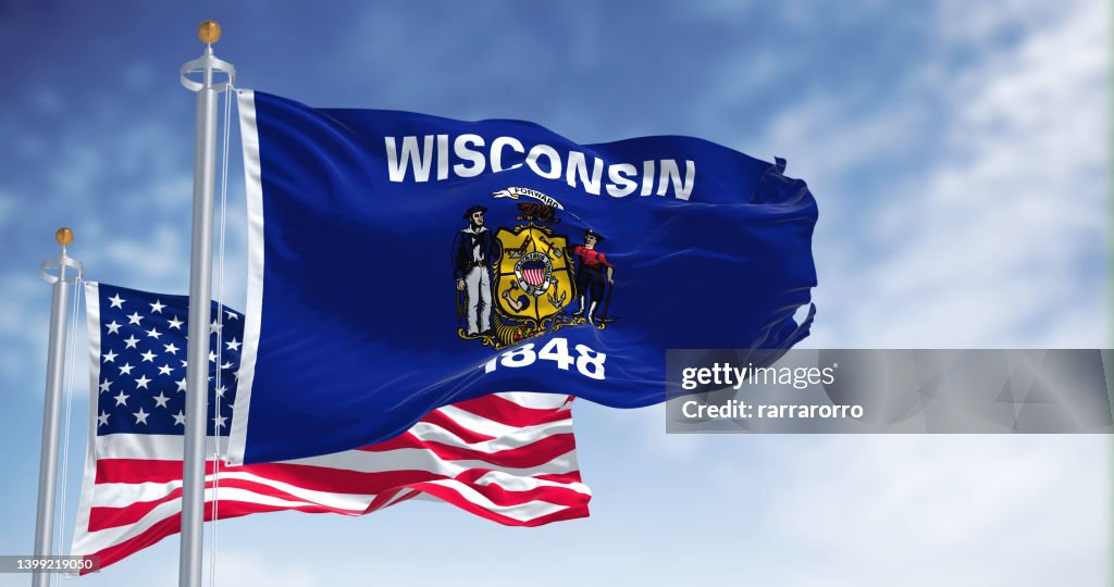 The Wisconsin state flag waving along with the national flag of the United States of America