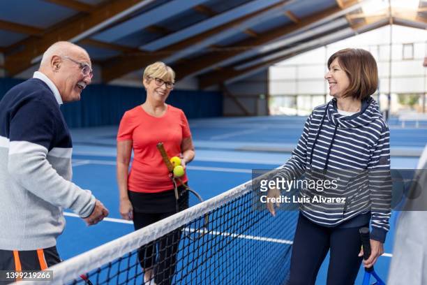 active seniors talking on tennis court after the game - 80s tennis players stock pictures, royalty-free photos & images