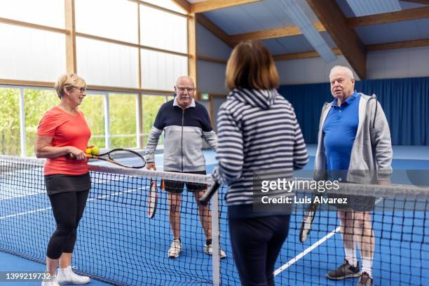 active senior couples talking after a tennis game on the court - 80s tennis players stock pictures, royalty-free photos & images