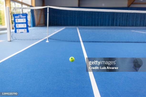 yellow tennis ball on blue tennis court - bouncing tennis ball stock pictures, royalty-free photos & images