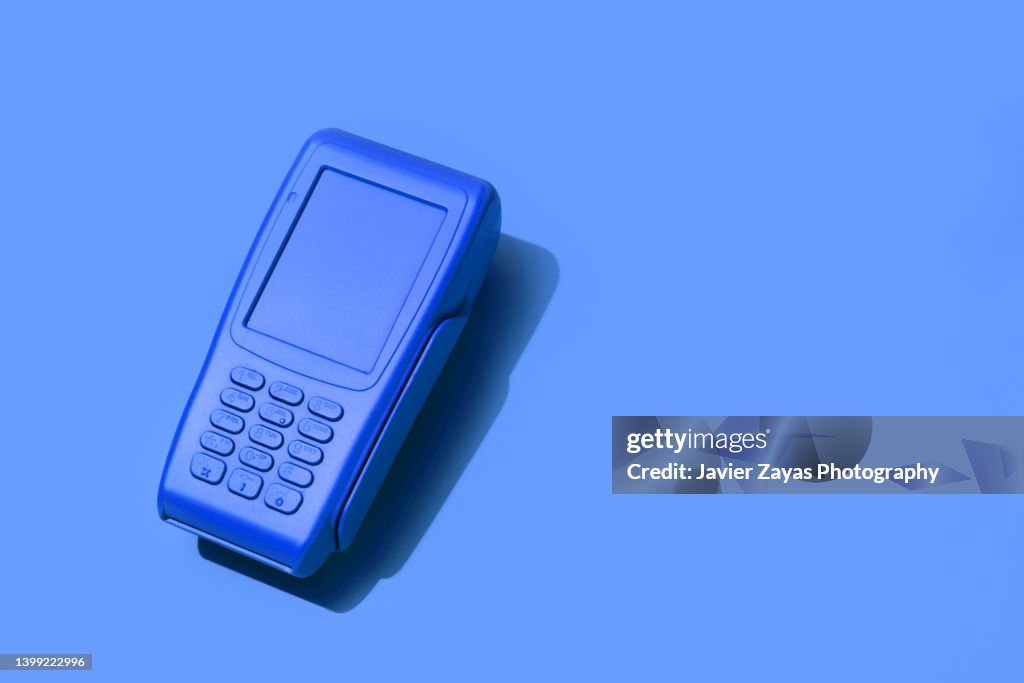 Blue Credit card POS terminal On Blue Background