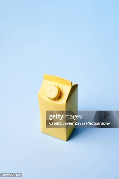 yellow small milk or juice box on blue background - milk pack 個照片及圖片檔