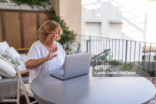 senior woman having a video call with her family - widow stock pictures, royalty-free photos & images