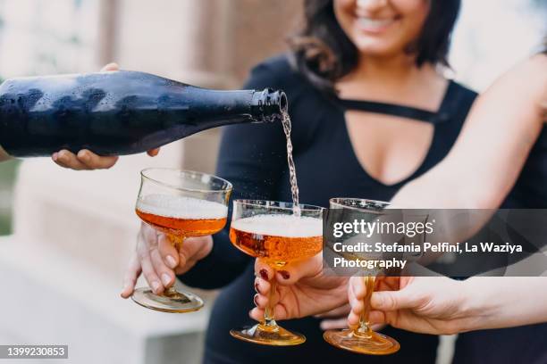 bottle of wine rose' being poured in drinking glasses - no alcohol stock-fotos und bilder
