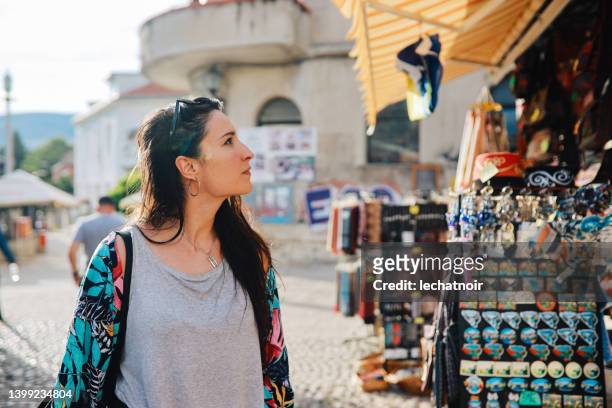 woman shopping for souvenirs in mostar old town - affordable stock pictures, royalty-free photos & images