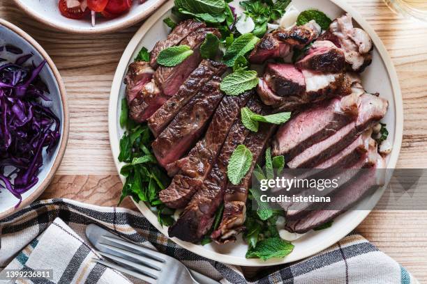 favorite meal. fresh roast beef meat steak on plate with salad - rib eye steak stockfoto's en -beelden