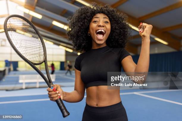 woman tennis player celebrating after winning a match on court - raqueta fotografías e imágenes de stock