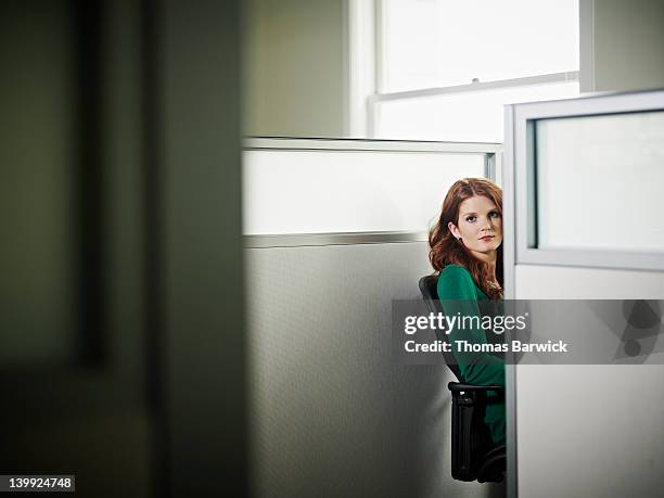 businesswoman sitting looking around cubicle - cubicle work stock-fotos und bilder