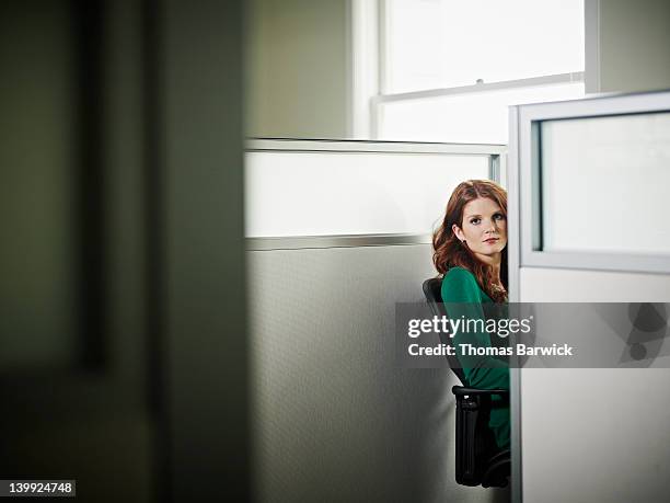 businesswoman sitting looking around cubicle - cubicle photos et images de collection