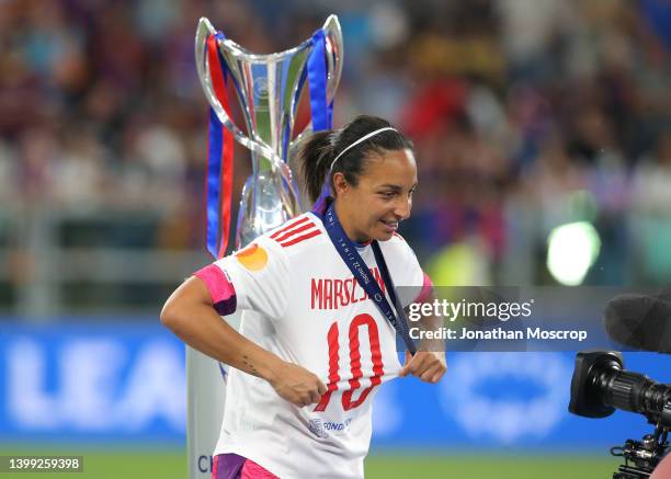 Sarah Bouhaddi of Lyon shows off Dzsenifer Marozsan's jersey after collecting her winners' medal during the trophy presentation ceremony following...