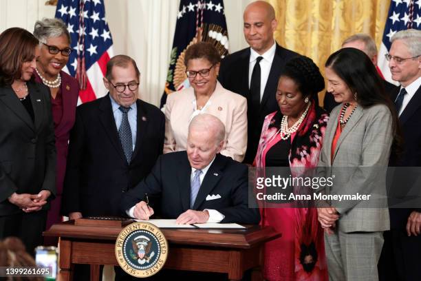 Flanked by U.S. Vice President Kamala Harris, lawmakers and cabinet members, U.S. President Joe Biden signs an executive order enacting further...