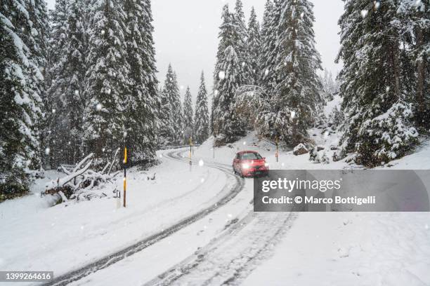 car driving on a mountain snowy road during snowfall - extreme weather snow stock pictures, royalty-free photos & images