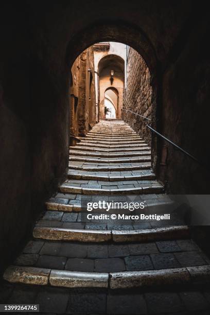 uphill alley with stairs in an old turf village, italy - steintreppe stock-fotos und bilder