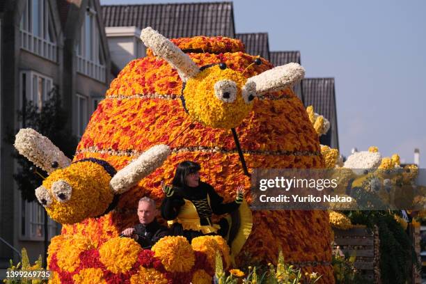 Woman in a bee costume dances atop a float, decorated with spring flowers, during the 75th Bloemencorso, a flower parade, on April 23, 2022 in...