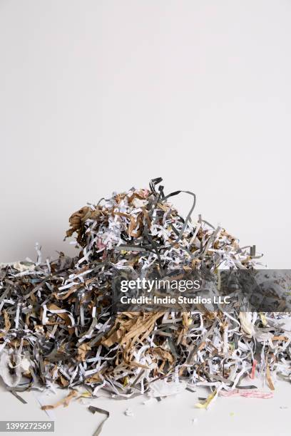 a dense pile of shredded paper on a light gray background - shredded newspaper stock pictures, royalty-free photos & images