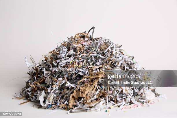 a dense pile of shredded paper on a light gray background - em tiras imagens e fotografias de stock