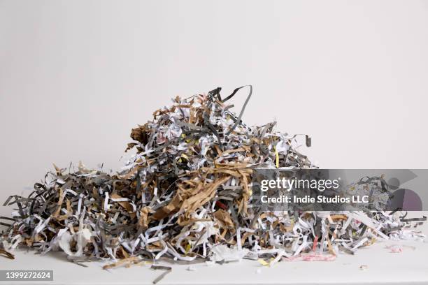 a dense pile of shredded paper on a light gray background - shredded newspaper stock pictures, royalty-free photos & images