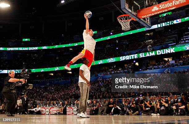 Chase Budinger of the Houston Rockets jumps over entertainer Sean "P.Diddy" Combs during the Sprite Slam Dunk Contest part of 2012 NBA All-Star...