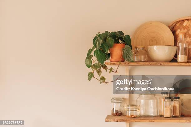 view on white simple modern kitchen in scandinavian style, kitchen details, syngonium houseplant on wooden table, white ceramic brick wall background - table brick wall wood stock-fotos und bilder
