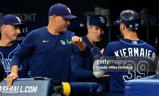 Kevin Kiermaier of the Tampa Bay Rays is congratulated after scoring a run by manager Kevin Cash in the first inning during a game against the Miami...