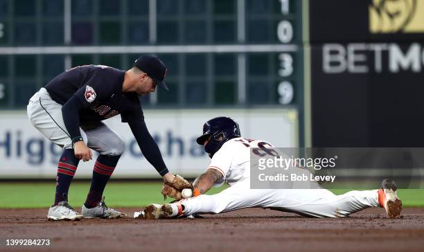 Jose Siri of the Houston Astros steals second base as Ernie Clement of the Cleveland Guardians applies the tag in the third inning at Minute Maid...